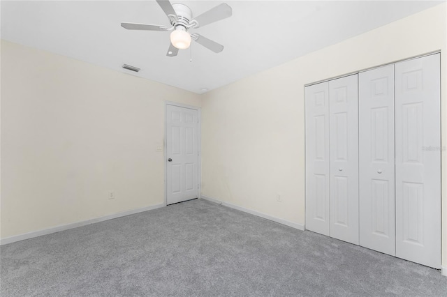 unfurnished bedroom with light colored carpet, a closet, and ceiling fan