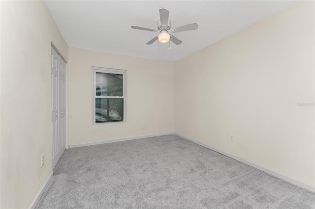 empty room with light colored carpet and ceiling fan