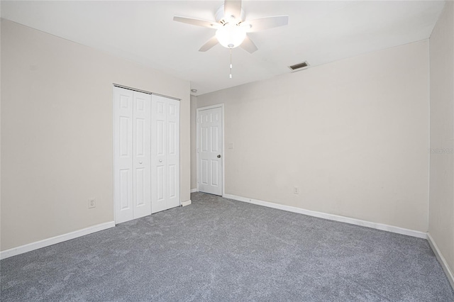 unfurnished bedroom featuring ceiling fan, a closet, and dark colored carpet