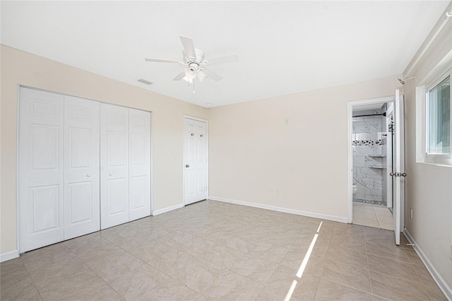 unfurnished bedroom with ensuite bathroom, light tile patterned floors, ceiling fan, and a closet