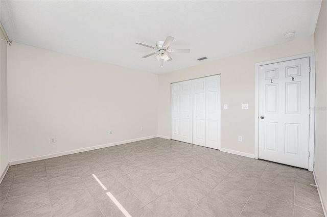 unfurnished bedroom featuring ceiling fan and a closet