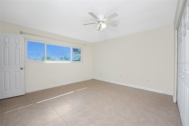 unfurnished bedroom featuring ceiling fan, light tile patterned floors, a textured ceiling, and a closet