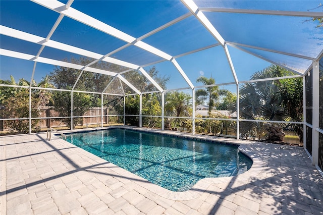 view of swimming pool with a patio area and glass enclosure