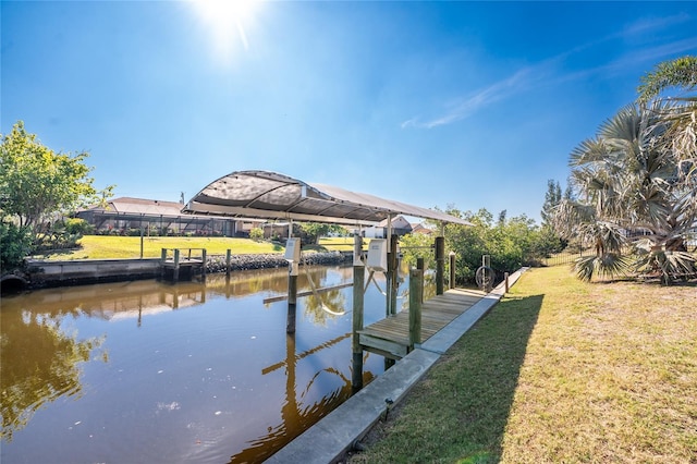 view of dock with a water view and a lawn