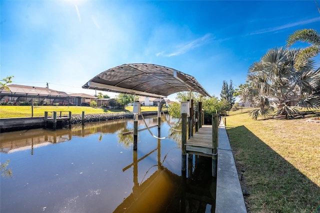 view of dock with a water view and a lawn