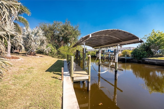 dock area with a water view and a lawn