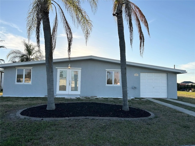 view of property exterior featuring french doors, a garage, and a yard