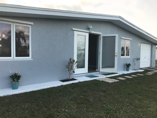 exterior space featuring a garage and a lawn