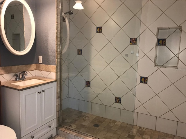 bathroom with vanity and a tile shower