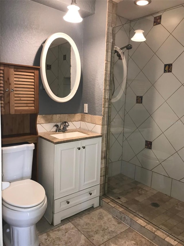 bathroom featuring vanity, toilet, and walk in shower