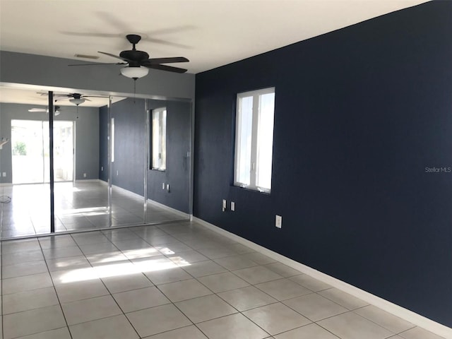 spare room with light tile patterned flooring and ceiling fan