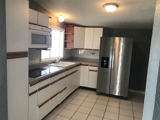 kitchen with sink, white cabinetry, stainless steel refrigerator with ice dispenser, a textured ceiling, and decorative backsplash