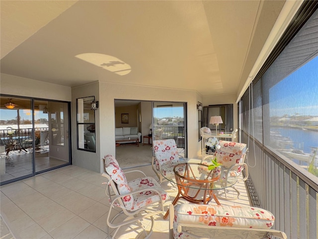 sunroom featuring a water view