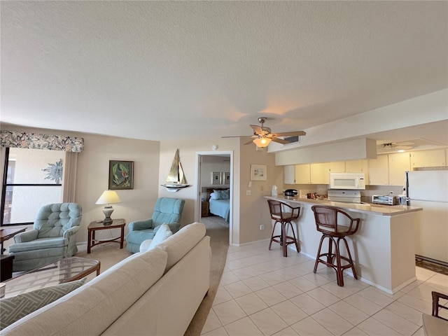 tiled living room featuring a textured ceiling and ceiling fan