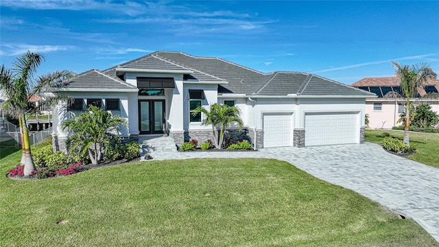 view of front facade featuring a garage, a front yard, and french doors