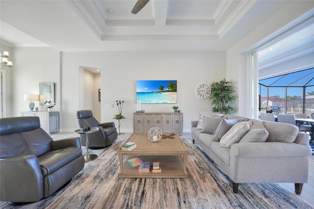 living room with crown molding, a towering ceiling, and coffered ceiling