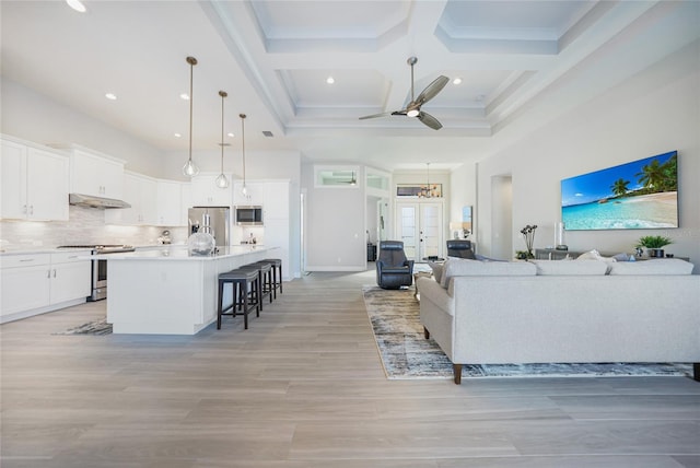 living room with beamed ceiling, coffered ceiling, ceiling fan, and french doors