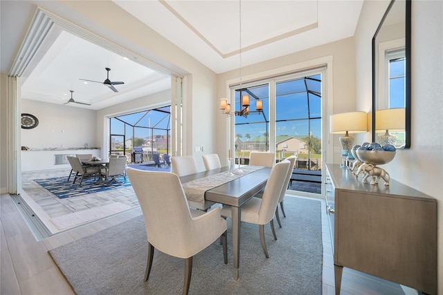 dining room with a raised ceiling and a chandelier