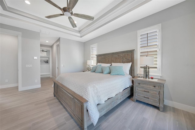 bedroom featuring ceiling fan and a tray ceiling