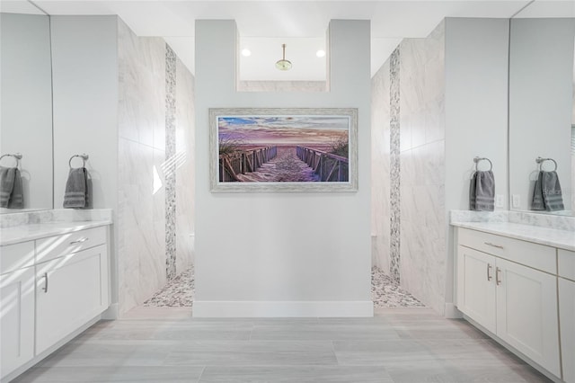 bathroom with vanity and a tile shower