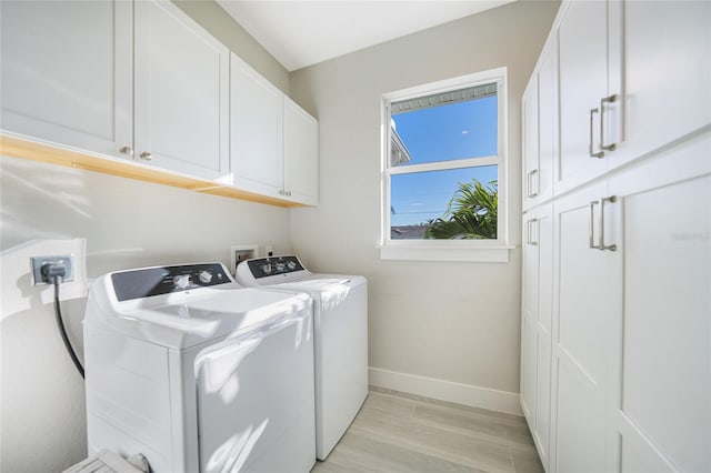 laundry area with cabinets, light hardwood / wood-style floors, and independent washer and dryer