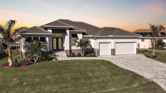 view of front of house featuring a garage and a lawn