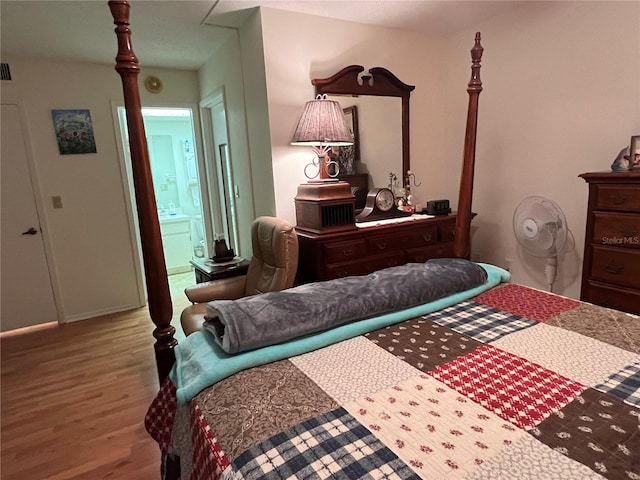 bedroom featuring connected bathroom and hardwood / wood-style floors