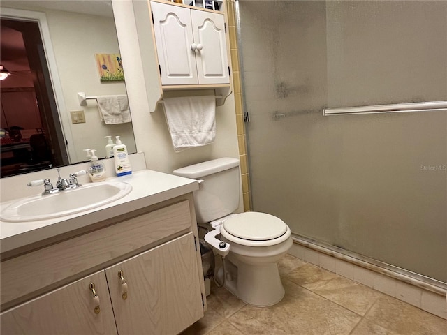 bathroom featuring vanity, tile patterned floors, toilet, and walk in shower