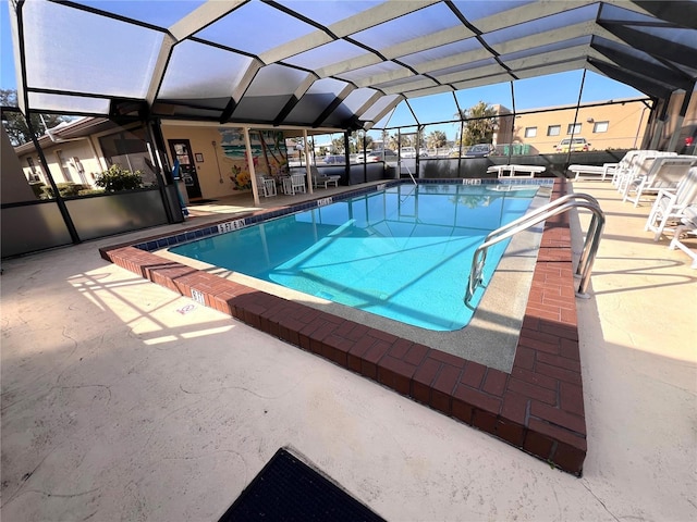 view of swimming pool featuring a patio area and glass enclosure