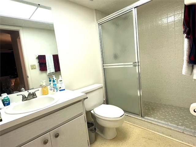 bathroom featuring vanity, an enclosed shower, and toilet