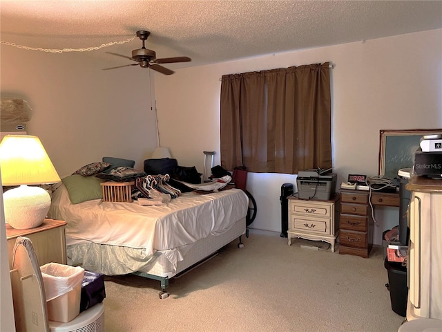 bedroom featuring ceiling fan, carpet floors, and a textured ceiling