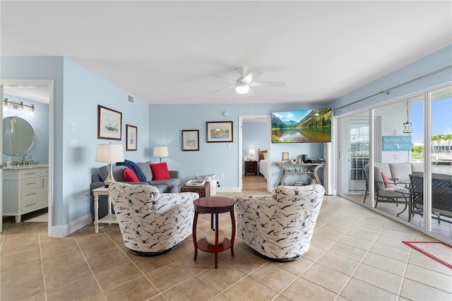 living room with light tile patterned flooring, ceiling fan, and sink