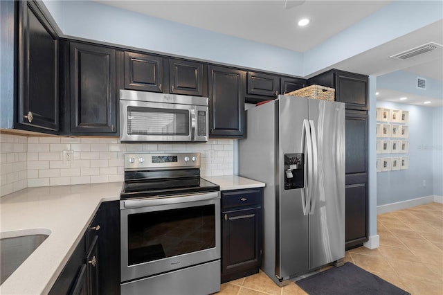 kitchen featuring appliances with stainless steel finishes, sink, decorative backsplash, and light tile patterned floors