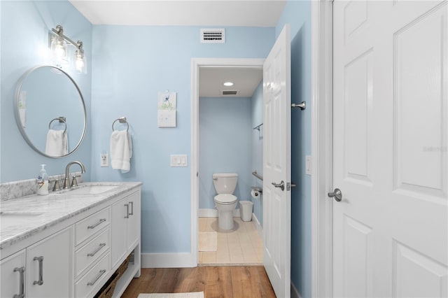 bathroom featuring vanity, hardwood / wood-style floors, and toilet