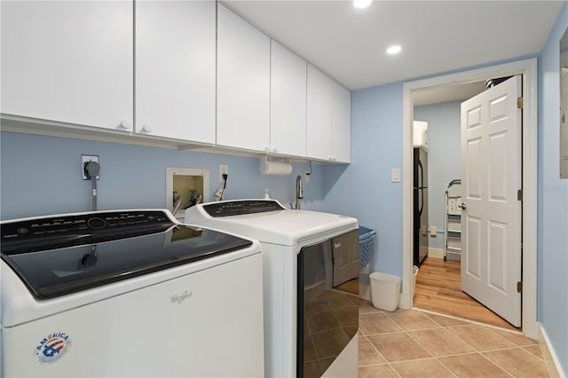 laundry area featuring cabinets, light tile patterned floors, and independent washer and dryer