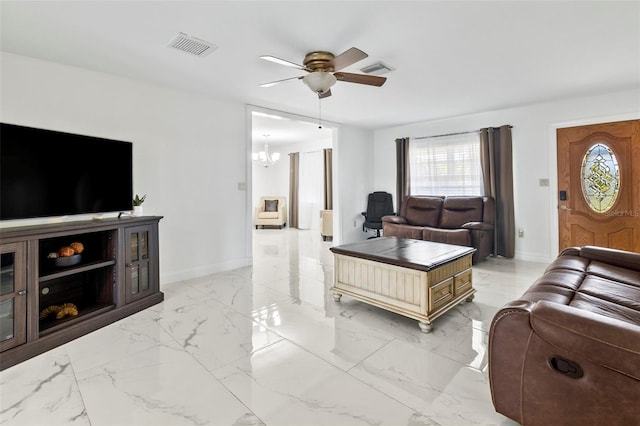 living room featuring ceiling fan with notable chandelier