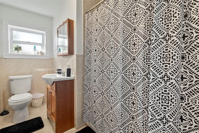 bathroom with tile patterned floors, toilet, tile walls, vanity, and a shower with shower curtain