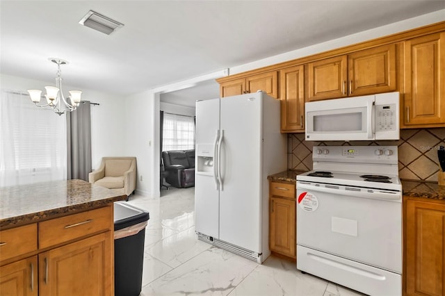 kitchen featuring pendant lighting, white appliances, dark stone countertops, an inviting chandelier, and tasteful backsplash