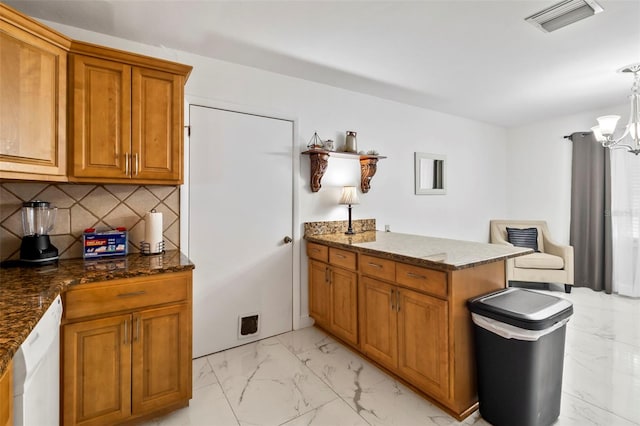 kitchen with pendant lighting, tasteful backsplash, dark stone countertops, a chandelier, and kitchen peninsula