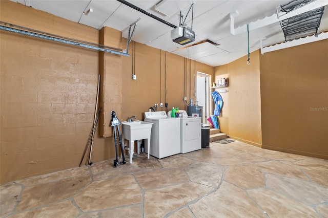 clothes washing area with sink, gas water heater, and washer and clothes dryer