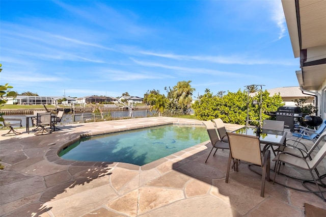 view of swimming pool featuring area for grilling, a patio area, and a water view