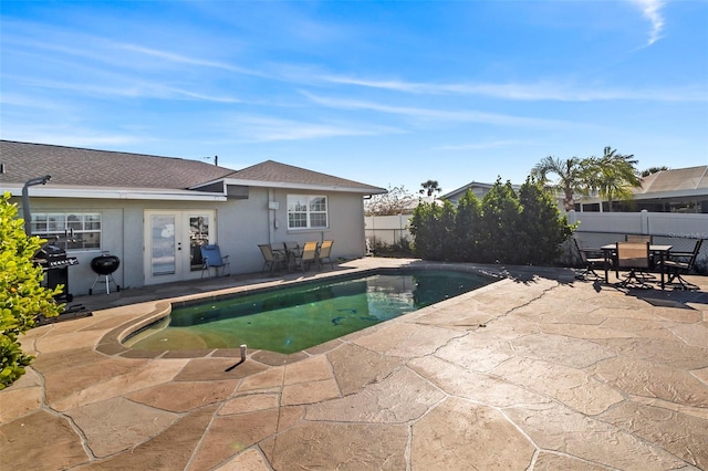 view of pool featuring a grill, a patio, and french doors