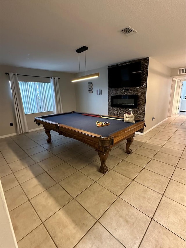 playroom featuring a large fireplace, light tile patterned floors, a textured ceiling, and billiards