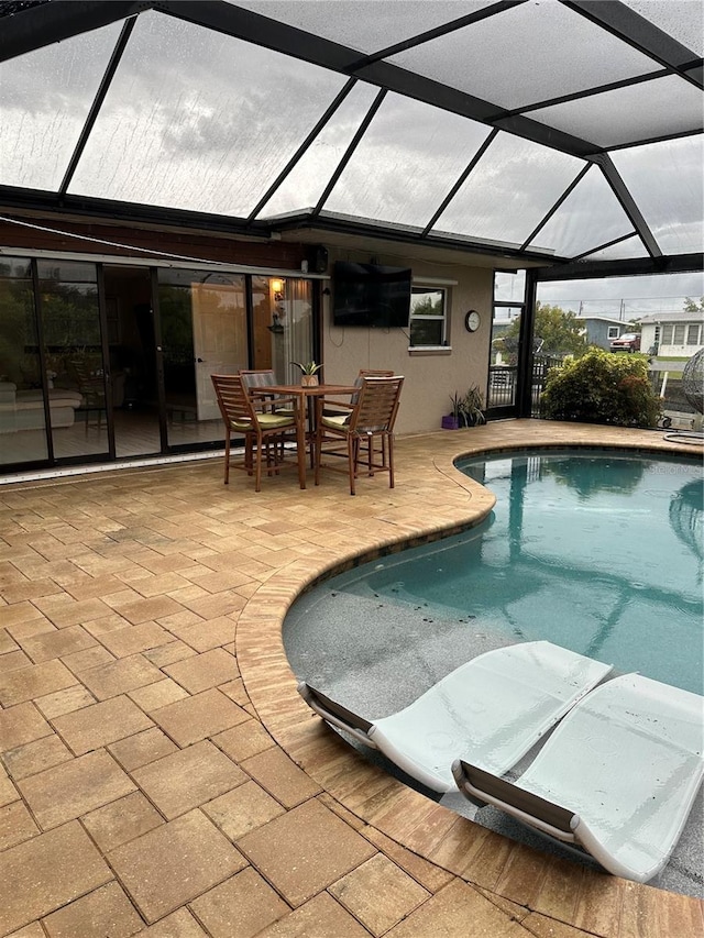 view of pool with a patio and a lanai