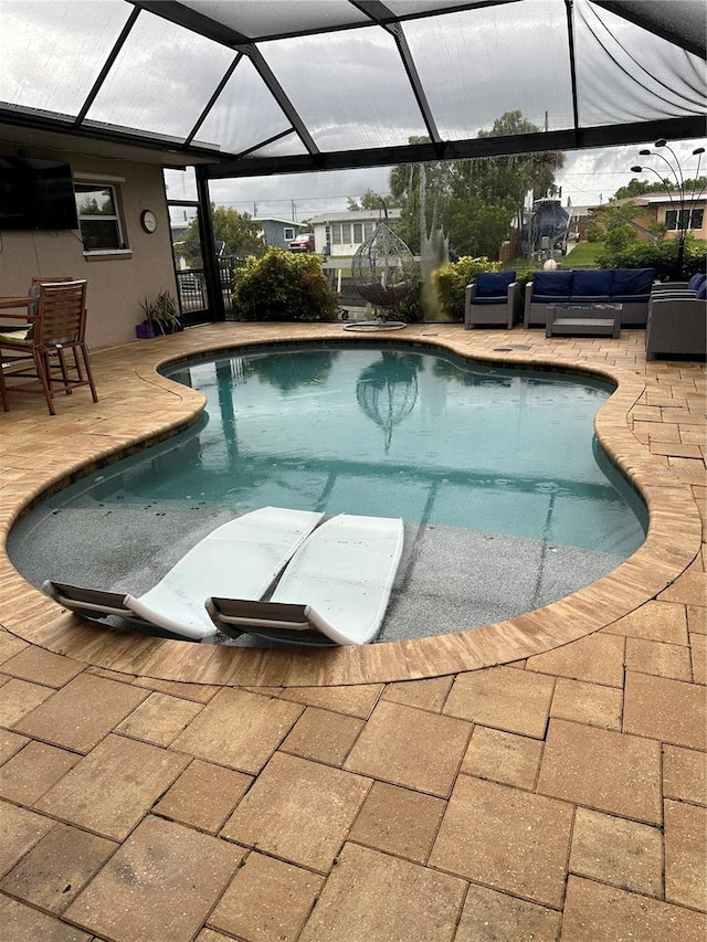 view of pool featuring an outdoor hangout area, a patio, and glass enclosure