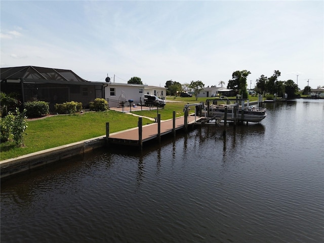 view of dock with a lawn and a water view