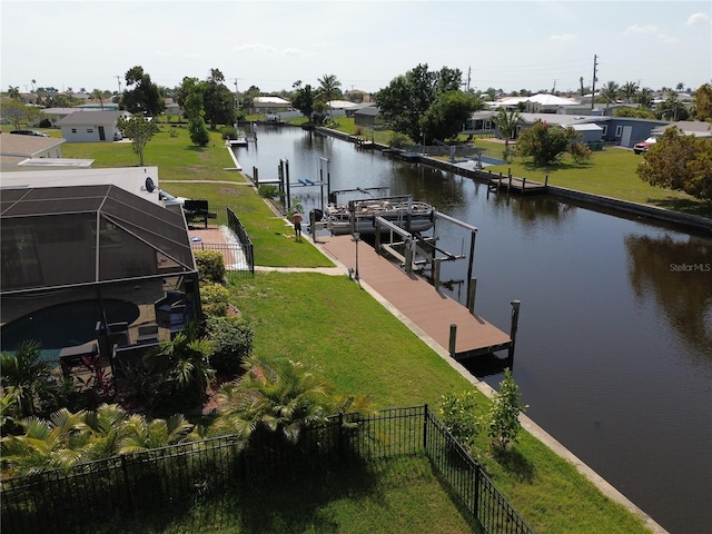 dock area with a water view, a lanai, and a lawn