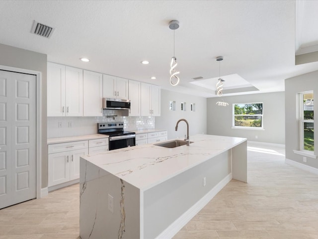 kitchen with white cabinetry, stainless steel appliances, sink, and hanging light fixtures