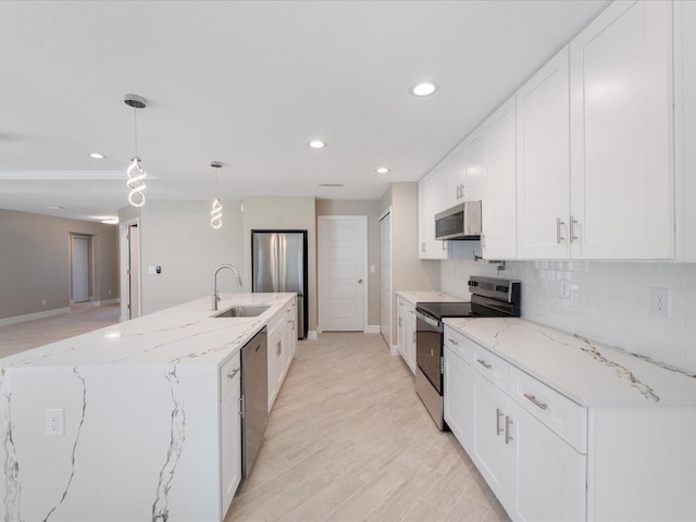 kitchen with white cabinetry, appliances with stainless steel finishes, sink, and hanging light fixtures