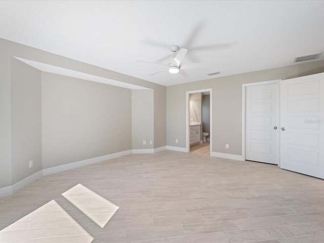 unfurnished bedroom with ceiling fan, ensuite bath, and light hardwood / wood-style flooring